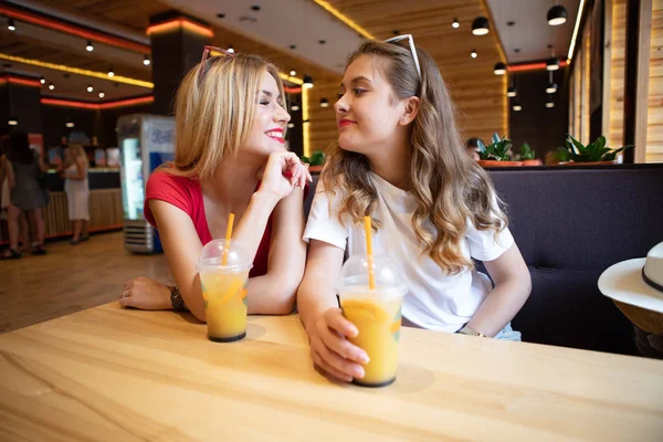 2人の友人がカフェでカクテルを飲む若いスレンダーな学生たちは喫茶店で休んでいる 笑って楽しんで — ストック写真