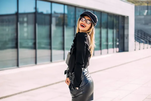 ストリートファッションの概念 若いスタイリッシュな女子学生の革のショートパンツと黒のスウェットシャツ — ストック写真