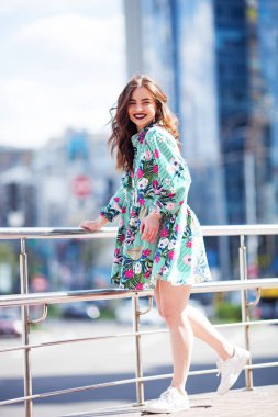 Dinamik olarak genç bir kız sokakta yürüyor. Rüzgarda dalgalanan saçlar. Sokak modası kavramı. Şehirde genç ve güzel bir model..