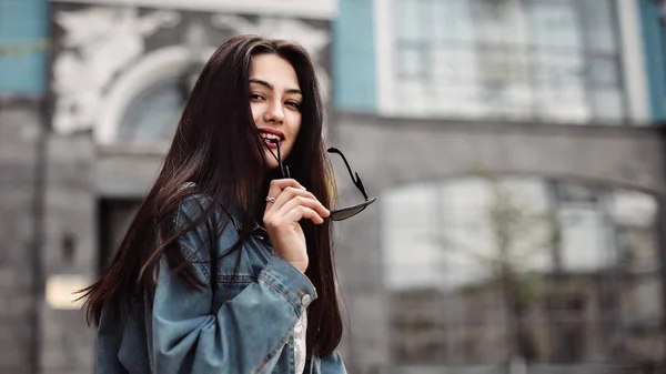 Ung vacker modell i staden. Vacker flicka håller solglasögon i handen närbild porträtt av en ung sexig tjej hipster. — Stockfoto