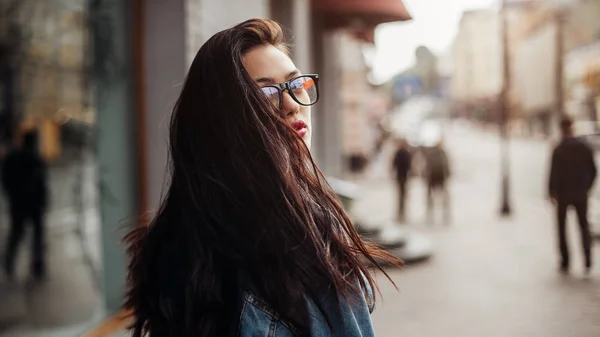 En förtjusande flicka som poserar på gatan på solig vårdag. Hon ser tillbaka.attraktiv snygg leende kvinna i glasögon — Stockfoto