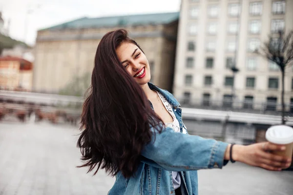 Emotional woman with an elegant hairstyle laughs while walking d — Stock Photo, Image