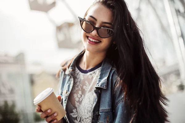 Glad attraktiv ung kvinna i solglasögon promenader i staden. — Stockfoto