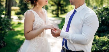 Gelin ve damadın evlilik yüzükleri ve elleri. Törende genç bir çift. Sevgililer birbirine yüzük takar..