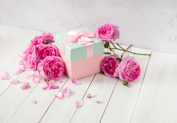 Fleurs Roses Coffret Cadeau Avec Ruban Papillon Sur Table Blanche Image En Vente