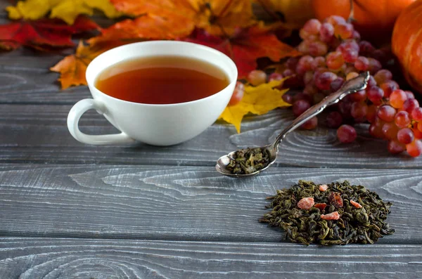 Cup of tea. Dry tea leaf.  Tea with spicy additives. Autumn background. White cup. Close up. Selective focus.
