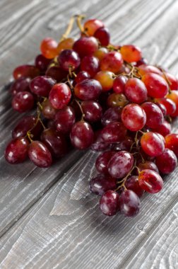 Ahşap bir masa üzerinde pembe üzüm demet. Hasat. Yakın çekim. Su damlacığı. Seçici odak.