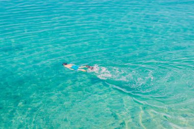 Havadan görünümü şeffaf turkuaz denizde dalış genç adam. Adam rahatlatıcı üstten görünüm onun tatil günleri.