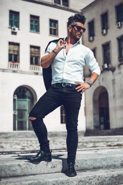 Başarılı bir genç iş adamı portresi merdivenlerden aşağı yürüyüş takım elbise giymiş. Şık genç adam kavramı