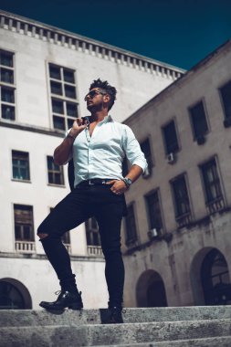 Başarılı bir genç iş adamı portresi merdivenlerden aşağı yürüyüş takım elbise giymiş. Şık genç adam kavramı