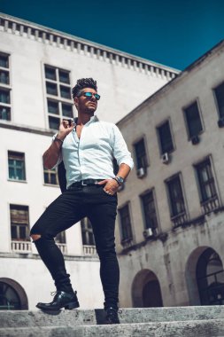 Başarılı bir genç iş adamı portresi merdivenlerden aşağı yürüyüş takım elbise giymiş. Şık genç adam kavramı