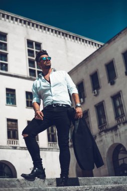 Başarılı bir genç iş adamı portresi merdivenlerden aşağı yürüyüş takım elbise giymiş. Şık genç adam kavramı