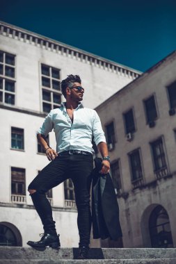 Başarılı bir genç iş adamı portresi merdivenlerden aşağı yürüyüş takım elbise giymiş. Şık genç adam kavramı