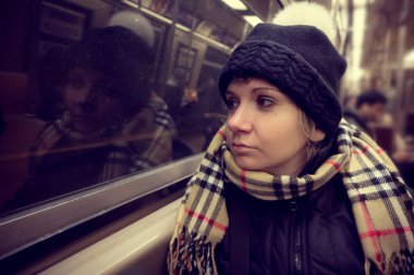 Yakındaki metro araba penceresinde oturan bir genç bayan. Kavram New York şehir hayatı