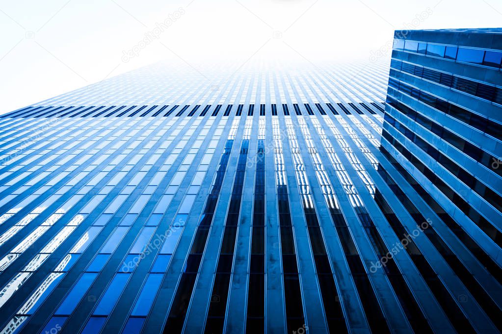 Low angle view skyscraper reflective glassy walls and windows background. Modern architecture pattern concept.