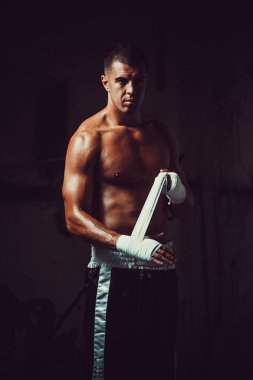 El bandaj ile kaydırma kas genç adam boksör. Savaşçı adam kavramı.