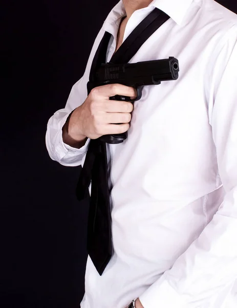 Man in black suit holding gun in hand. Secret agent, mafia, bodyguard concept.