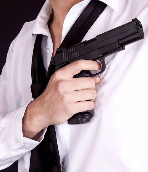 Man in black suit holding gun in hand. Secret agent, mafia, bodyguard concept.