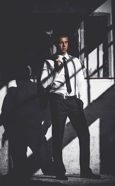 Awesome stylish men in elegant suite posing in abandoned place. Elegance and Luxury Business Man concept. Dark Toned Image.