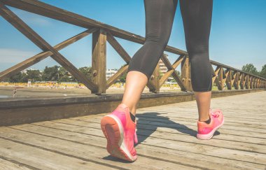 Ahşap köprüde çalışan sportif kadının arka görünümü  