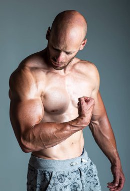 Kaslı adam pazı gösteren, enerji arka plan üzerinde güçlü kollar.