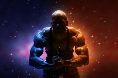 Gömleksiz güçlü adam koyu kozmik arka plan üzerinde poz