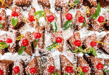 Hindistan cevizi talaşı ile serpilir ve kiraz ile dekore edilmiş bir çikolatalı kek