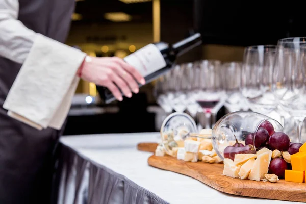 De ober serveert de wijn en kaas proeverij gebied — Stockfoto