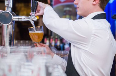 Garson fotoğrafı bira bir cam içine dökülen.