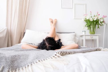 bir sabahlığı genç kadının fotoğrafını bir yatakta yatıyor