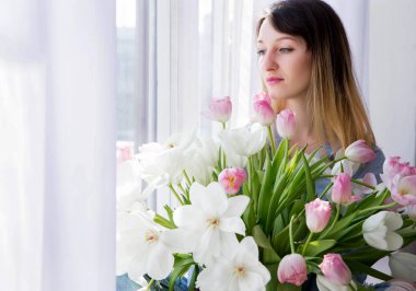 Genç kadının fotoğrafını bir buket çiçek ile bir pencere oturur