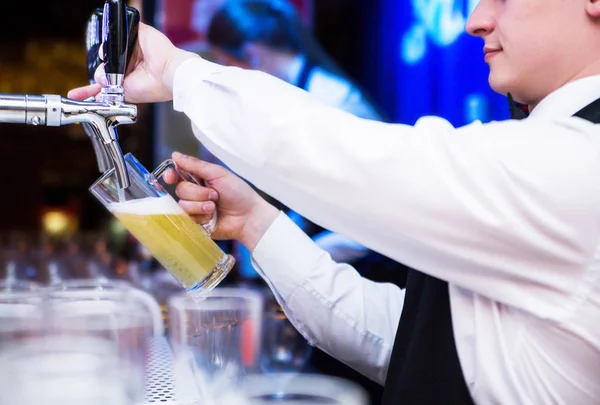 Garson fotoğrafı bira bir cam içine dökülen.