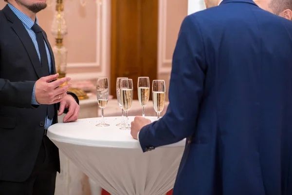 photo of men drink champagne at the buffet table