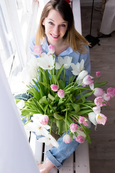 Genç kadının fotoğrafını bir buket çiçek ile bir pencere oturur