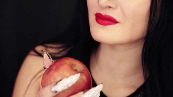 Uma jovem bruxa com uma maçã nas mãos — Vídeo de Stock