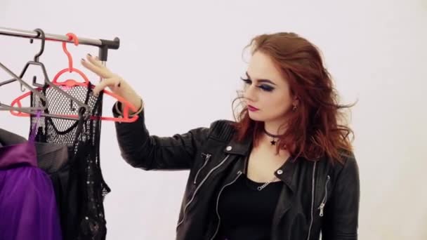 Ένα κορίτσι στο στυλ του rock επιλέγει ρούχα — Αρχείο Βίντεο