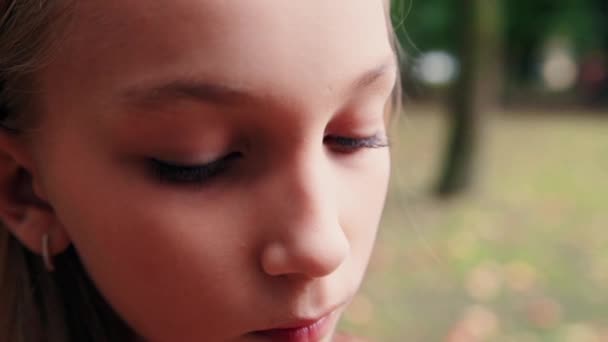 A teenage girl touches her hair and thinks about something — Stock Video