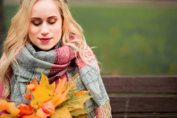 Ein Mädchen in einem herbstlichen Park mit einem Strauß Blätter — Stockfoto