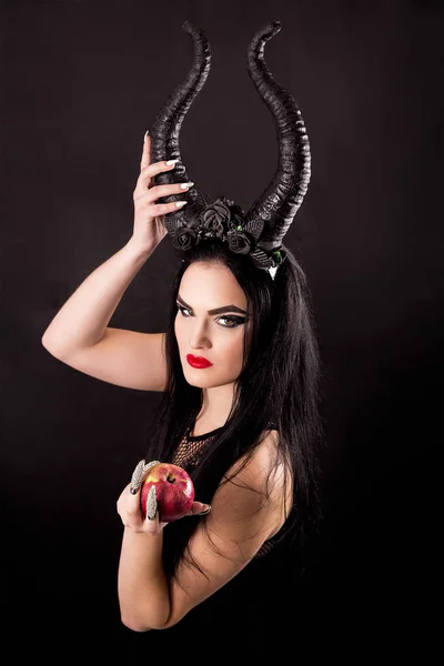 Una manzana en manos de una bruja con cuernos — Foto de Stock