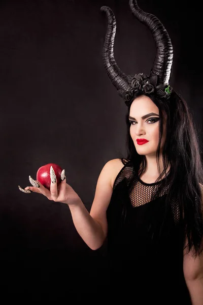 Uma maçã nas mãos de uma bruxa com chifres — Fotografia de Stock