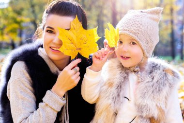 Anne ve kızı fotoğrafı sonbahar yaprakları ile gözlerini kapat