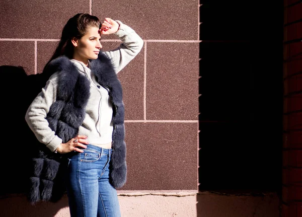 Foto Menina Colete Pele Contra Fundo Parede Tijolo — Fotografia de Stock