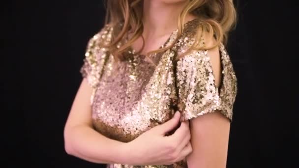 Девушка в блестящем золотом платье на черном фоне — стоковое видео