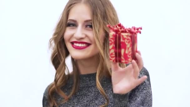 Lány-egy ajándék a kezükben fehér alapon — Stock videók