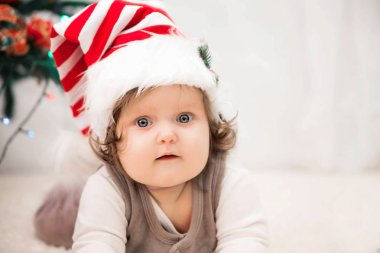 Bebek halı üzerinde Noel şapkalı