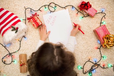 Kız yatıyor ve Noel Baba'ya bir mektup yazar. Üstten görünüm