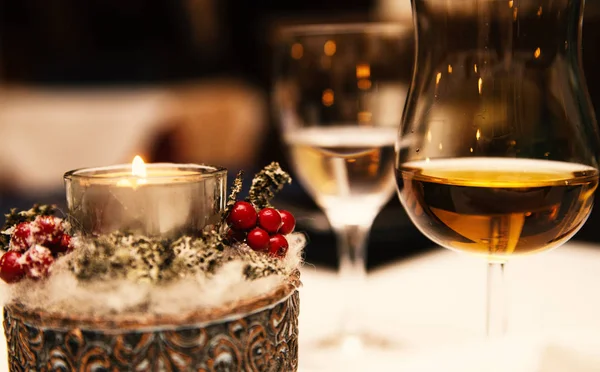 Glas Alkohol und eine Kerze auf dem Tisch — Stockfoto