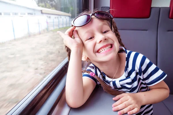 Petite fille dans le train regarde par la fenêtre — Photo