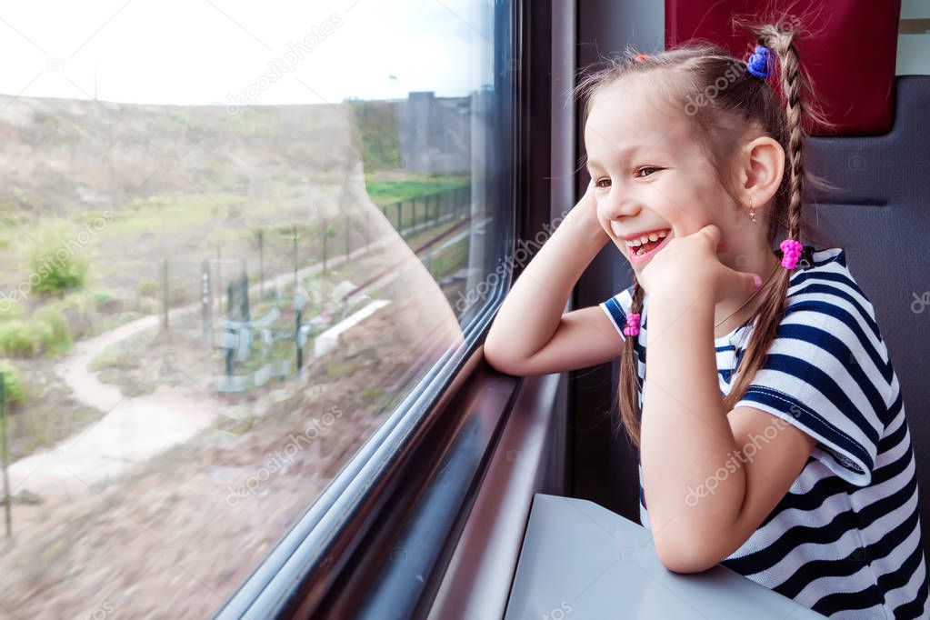 little girl on the train looks out the window