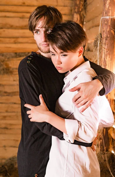 Junger Mann und Frau umarmen sich in Holzhaus — Stockfoto